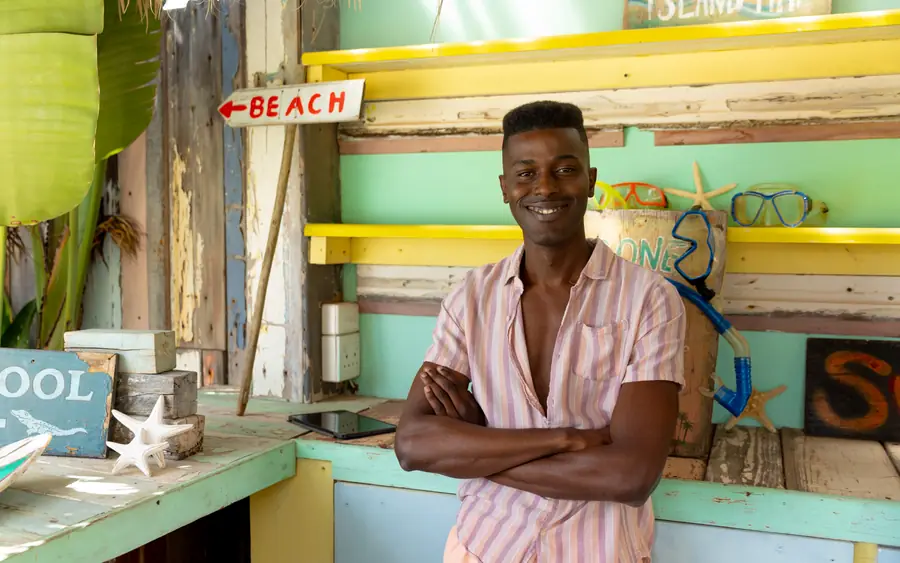 A shop owner in his beach shop, arms folded
