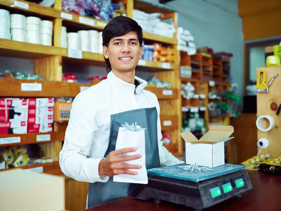 A shopkeeper at his counter with a set of scales