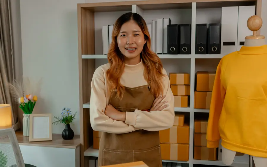 A shop owner in her store, arms folded