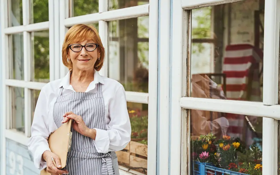 A florist in the doorway of her shop